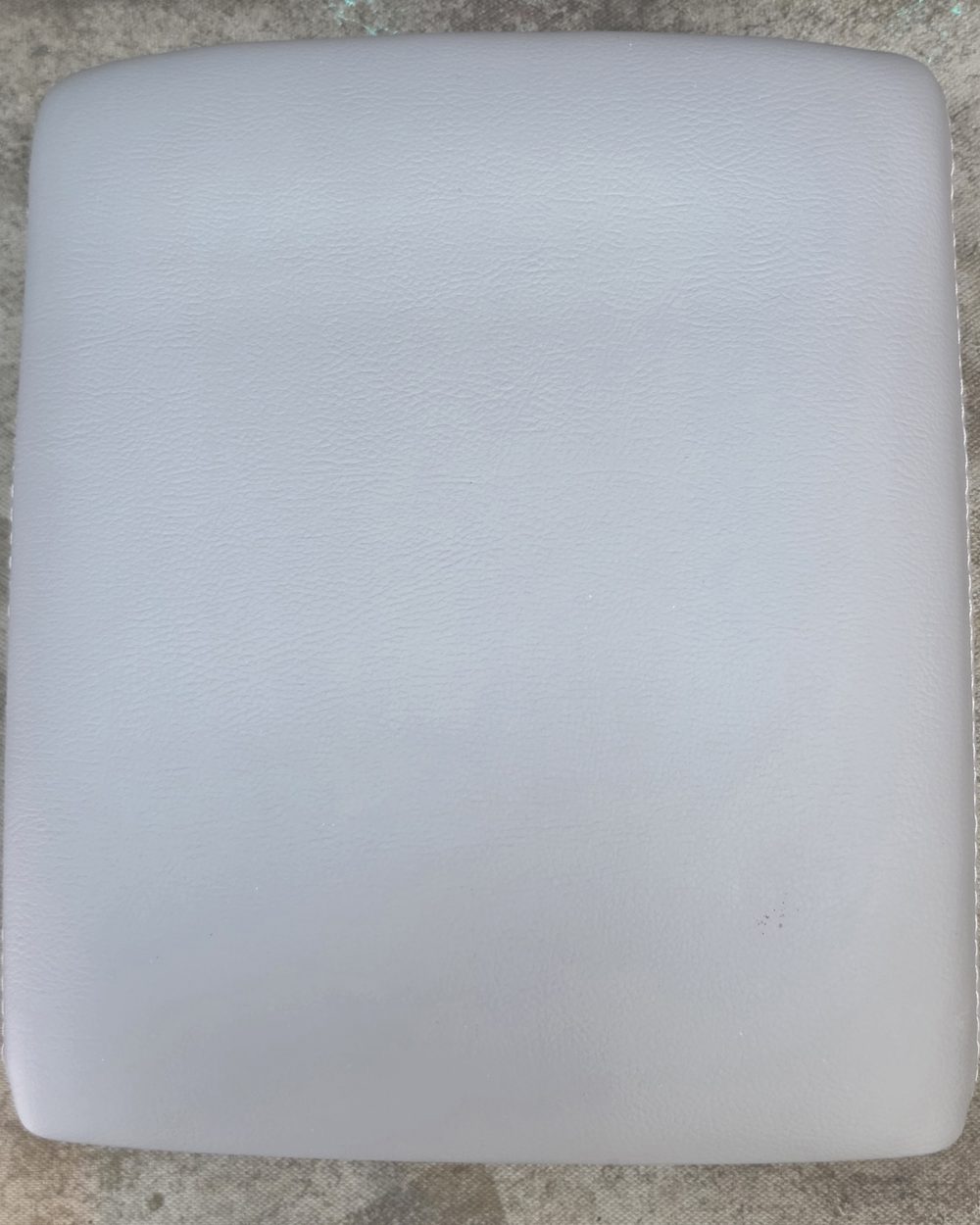 The same console lid after Bob recovered it, showing a smooth unbroken grey cover with clean wrapped edges.